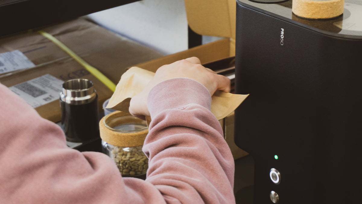 Megan sample-roasting coffee on the IKAWA Pro50 at Ómra